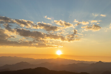 Fototapeta premium Sunset or sunrise mountain peaks colorful sky. Colorful Sky At Sunset Dawn Sunrise. Sun Over Skyline, Horizon. Warm Colours.
