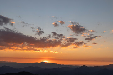 Sunset or sunrise mountain peaks colorful sky. Colorful Sky At Sunset Dawn Sunrise. Sun Over Skyline, Horizon. Warm Colours.