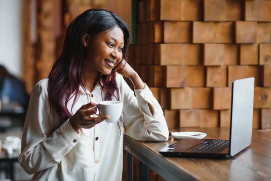 Focused young african american businesswoman or student looking at laptop, serious black woman working or studying with computer doing research or preparing for exam online