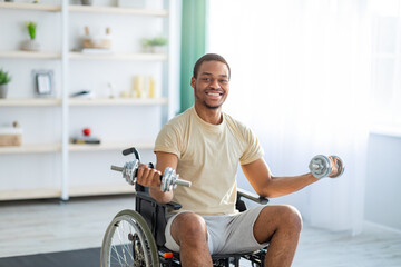 Physical activities for paraplegic people. Impaired black man in wheelchair making rehab exerises with dumbbells at home