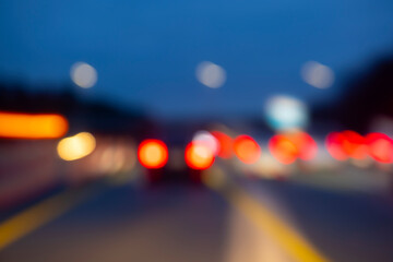 Blurred moving lights on a german Autobahn seen through the windshield while driving at night in...