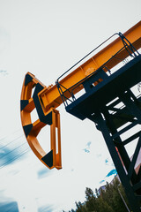 Oil rig pump rocking chair against. Crude oil production from the ground. Petroleum production, natural gas. The concept of oil production and the cost of a barrel of oil, vertical frame