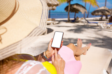 Woman using mobile phone while relaxing on tropical beach