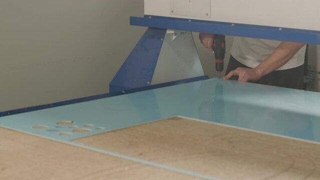 Production of advertising signs in the factory. Screwdriver tightens the screw