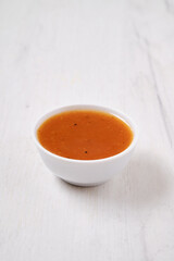Small bowl with spicy orange sauce