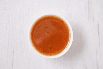 Top view of small bowl with spicy orange sauce