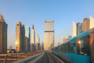 Fototapeta na wymiar Metro System. View from window of subway car in Dubai in evening rays of sunset. Underground station train goes past skyscrapers. Departing train rushes towards. High quality photo