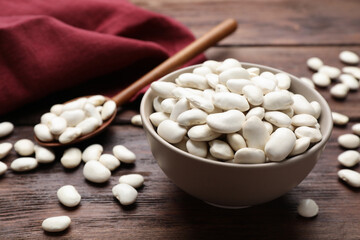 Raw white beans on wooden table, closeup