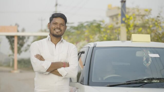 Happy confident cab driver with crossed arms standing next to car by looking at camera - concept of self-employed, positive emotion and profesional occupation.