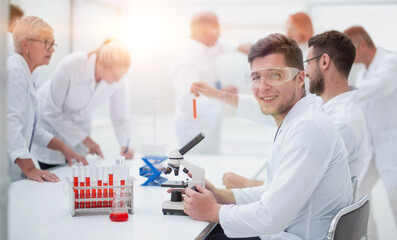 young scientist and his colleagues work in the laboratory.