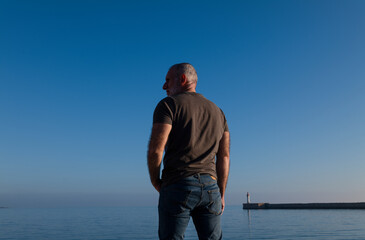 Adult man against sea and sky with lighthouse in background. Almeria, Spain