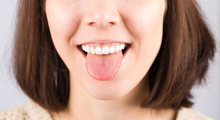 Teen girl with bob haircut, white teeth and protruding tongue