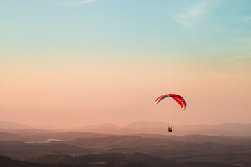 Fototapeta na wymiar Pico do Gavião, Andradas, Minas Gerais, Brazil: sunset at the top of mantiqueira mountain with paraglaider flight
