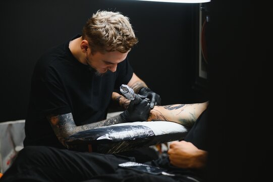 Professional tattoo artist working in his tattoo studio.