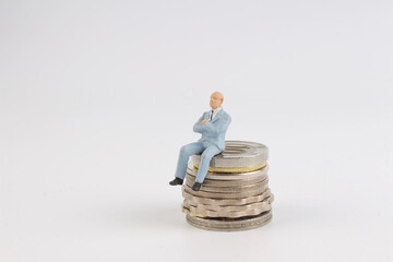  miniature men sit on coins