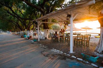 Fototapeta na wymiar Family enjoying dinner in a restaurant on the beach at sunset.
