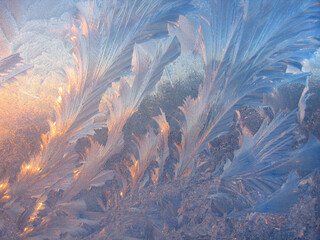 Ice pattern and sunlight on window glass early in the morning