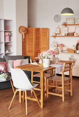Pink living room and kitchen. Studio apartment. Loft interior. Shelves and spring decor in room. Rent and delivery of housing. Hostel and hotel.