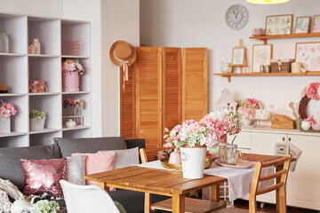 Pink living room and kitchen. Studio apartment. Loft interior. Shelves and spring decor in room. Rent and delivery of housing. Hostel and hotel.