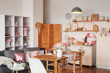 Pink living room and kitchen. Studio apartment. Loft interior. Shelves and spring decor in room. Rent and delivery of housing. Hostel and hotel.