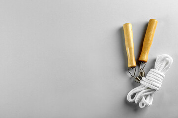 Skipping rope on light grey background, top view. Space for text
