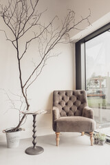 Salon waiting room with chair in the window and branch decoration