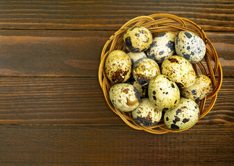 quail eggs in a basket on a wooden background. spring, Easter or healthy organic food concept.