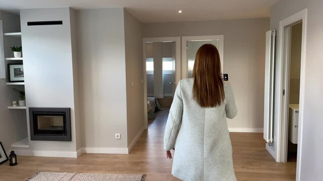 Female real estate agent making a video with her gimbal to show it to her clients in a video call or to upload it to social networks and promote the sale of a property or a property for sale. 