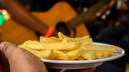 Potato Spicy French Fries or Simply Fries plate on hand in a party