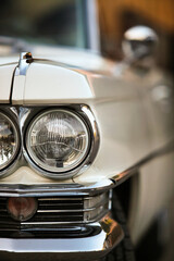 Car, vintage car, close-up of the headlight on the grille, lamp with chrome surround..