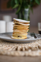Stack of pancakes with sugar powder and cup of coffee. Close up. Breakfast concept. Home made pancakes.