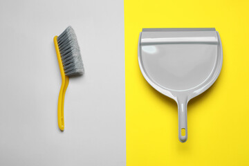 Plastic hand broom and dustpan on color background, flat lay