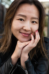 Close up portrait of an attractive Asian American girl, resting her head on her hands