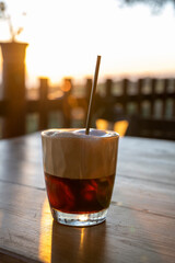 Cup of Latte coffee on wooden coffee table.  Coffee break in the morning, relaxing and refreshing concepts. A white coffee cup on wooden table in the garden.