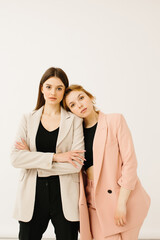 Stylish young women in pastel outfits standing together, fashion concept - stock photo