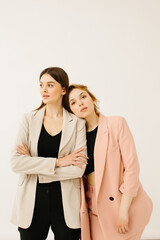 Stylish young women in pastel outfits standing together, fashion concept - stock photo