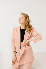 Young woman in trendy pastel suit on white background
