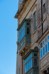 Fototapeta na wymiar Valletta, Malta - 01 06 2022: Detail of a traditional facade with a blue sky background