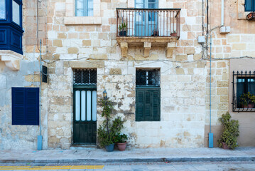 Fototapeta na wymiar Valletta, Malta - 01 06 2022: Traditional facade of residential houses in Mediterranean style
