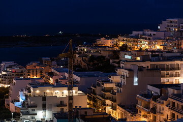 Fototapeta na wymiar Mellieha, Malta - 01 07 2022: High angle view by night over the valley towards the seaside
