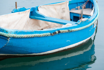 Fototapeta na wymiar Marsaxlokk, Malta - 01 07 2022: Small blue vessel at the harbor