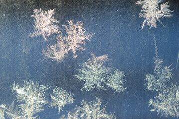 It is a pattern of frost on the glass of a window. White textured frosty crystal snowflake.