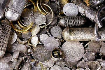 A lot of stacked gold bullion bars and gold coins and silver coins in a treasure sack. Treasure background. 
gold and silver jewelry. Ancient treasure. Pirate treasure and gold and silver filled crate