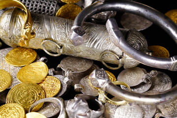 A lot of stacked gold bullion bars and gold coins and silver coins in a treasure sack. Treasure...