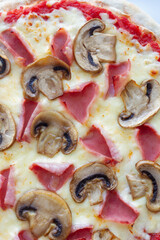 Prosciutto and mushroom pizza on a marble background