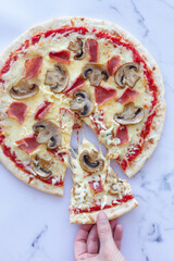 Prosciutto and mushroom pizza on a marble background