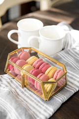 Naklejka na ściany i meble Pink French Macarons in Gold and Glass Box, Valentine's Day Dessert, Fancy Dessert, White Coffee Cups, Copy Space