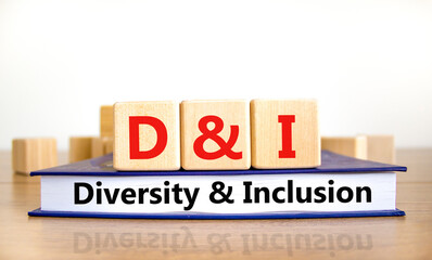 D and I, Diversity and inclusion symbol. Concept words D and I, diversity and inclusion on wooden cubes on book on beautiful white background. Business, D and I, diversity and inclusion concept.