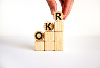 OKR, objectives and key results symbol. Concept words OKR objectives and key results on wooden circles on a beautiful white background. Business OKR objectives and key results concept. Copy space.