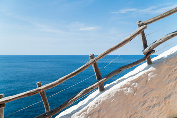 Fototapeta na wymiar Wood railing with ocean views in Alaior, Menorca (Spain).